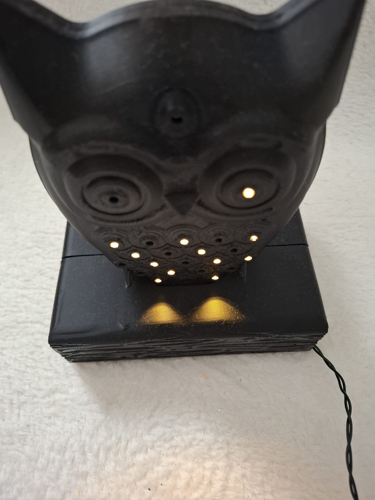 Leucht-Eule mit 24 LEDs – Schwarze Dekofigur auf Holzbalken mit Batteriefach im Sockel