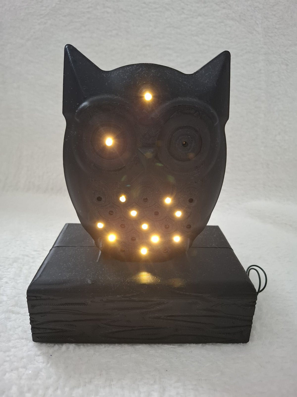 Leucht-Eule mit 24 LEDs – Schwarze Dekofigur auf Holzbalken mit Batteriefach im Sockel
